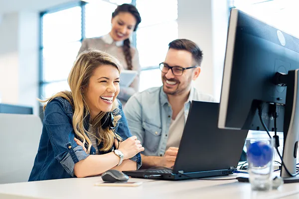 group of office workers smiling at a desk